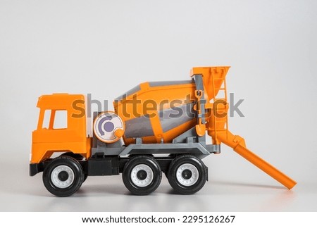 Multi-colored plastic children's toy cars on a white background. Orange concrete truck.