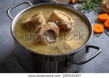 Boiled bone and broth. Homemade beef bone broth is cooked in a pot on. Bones contain collagen, which provides the body with amino acids, which are the building blocks of proteins. Royalty-Free Stock Photo #2295141457