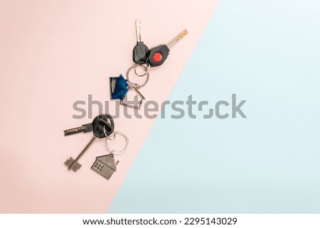 Keys with keychain with shape of house on a two colored background