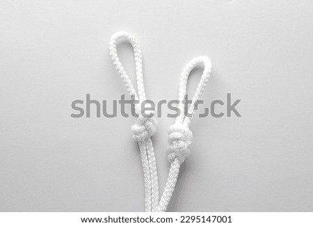 Rope with a knots and loops on gray background Royalty-Free Stock Photo #2295147001