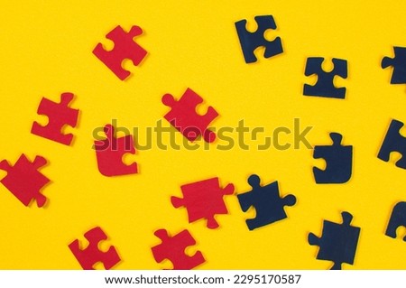 Colorful jigsaw puzzle  pieces on yellow background. Top view.
