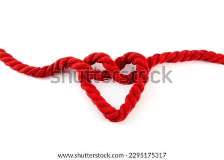 Red rope with a heart shaped knot isolated on white background