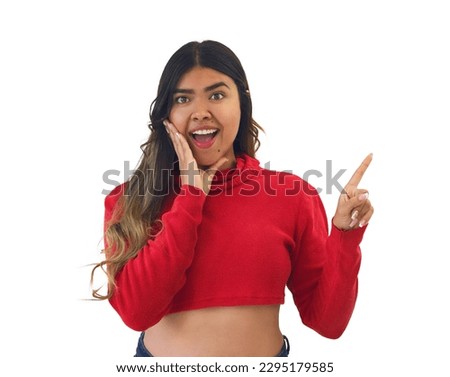A hispanic brunette isolated woman wearing a red crop top pointing his finger to the side