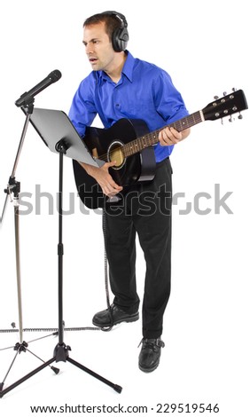male singer holding a guitar and wearing headphones on white background