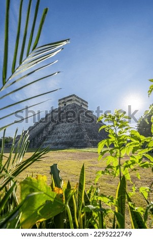 Photo of the pyramid in Chichen Itza taken through the plants. Royalty-Free Stock Photo #2295222749