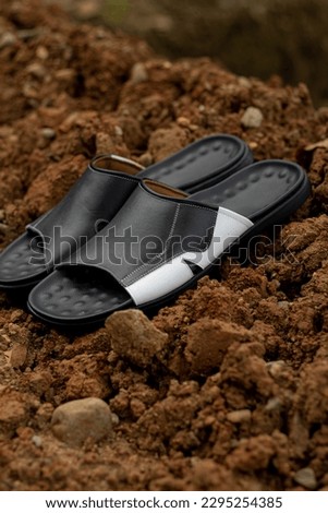 Black leather sandals, in the photo in an open room. outdoor leather sandals. slippers leather 
