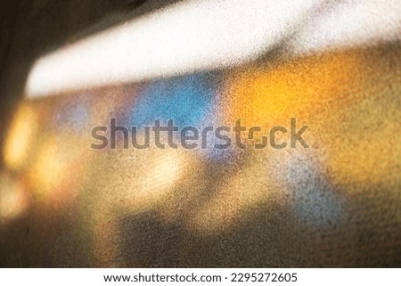 colorful stain glass reflecting onto wall Royalty-Free Stock Photo #2295272605