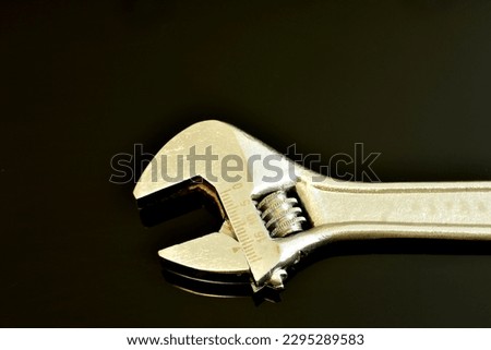 The working part of an adjustable locksmith wrench, the size of the throat is changed by a worm gear that rotates with a finger.