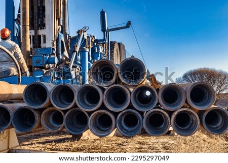 Pipes for a well close-up. Powerful drilling rig against a cloudy sky. Drilling of deep wells. Drilling equipment. Mineral exploration. Extraction of gas and oil