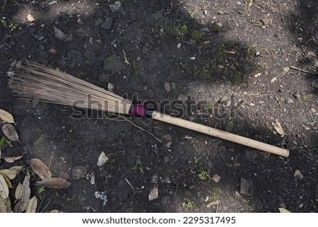 The broomstick in the close-up photo is placed on the ground.