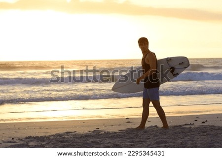 Sunset, surfing man and walking at the beach with surfboard. Athlete, summer vacation or holiday and professional male surfer training or exercising water sports at the ocean or sea on mockup space Royalty-Free Stock Photo #2295345431