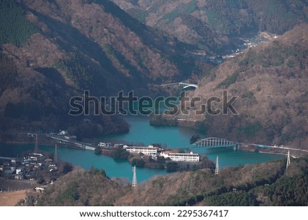 Japan has many beautiful dams and mountains, offering breathtaking views of nature. One such example is the Oshika Dam, with its scenic reservoir and surrounding mountains, creating a picturesque land Royalty-Free Stock Photo #2295367417