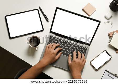 Overhead view of woman hands typing on laptop with blank empty mockup screen, watching webinars, working remotely