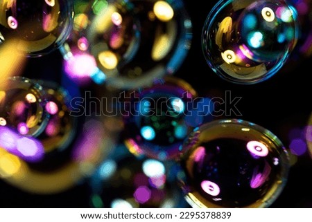 of the splendid soap bubbles on a black background, the colors and reflections of the soap bubbles.
