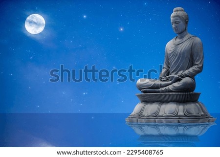 Buddha statue sitting on blue sky background.