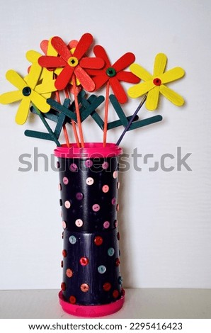 DIY Art and craft colourful popsicles sticks painted in different colors and make into beautiful flowers. Icecream containers painted and decorated with button to used as flower vases. Satisfying.
