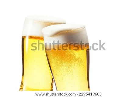 Beer, cheers, two glasses piled up Foam overflows from the glass Royalty-Free Stock Photo #2295419605