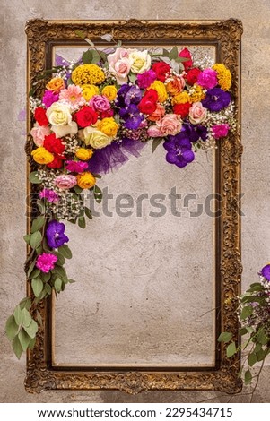 vintage frame decorated with spring flowers on it and old plaster in the background