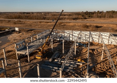 Drone photography of warehouse being built by construction workers during spring morning