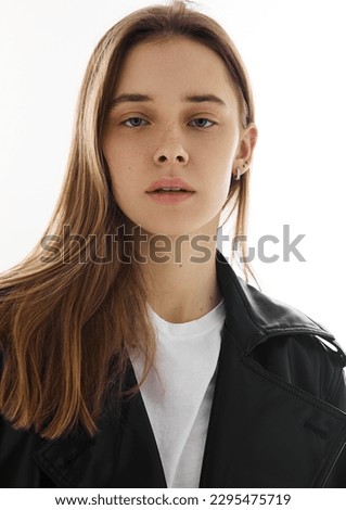 Portrait of beautiful young fashion model girl with leather jacket and white t-shirt on white.