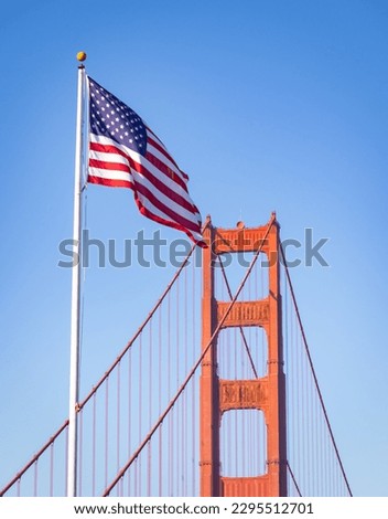 A picture of an American flag next to the Golden Gate Bridge Tower.