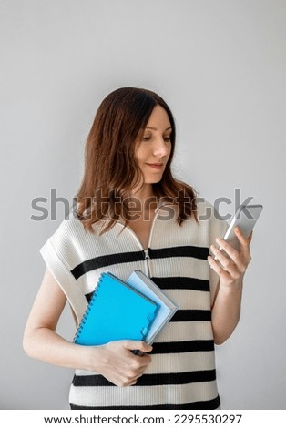 Woman manager smiling hold smartphone, look screen. Working in office, using mobile cell phone. Home office 