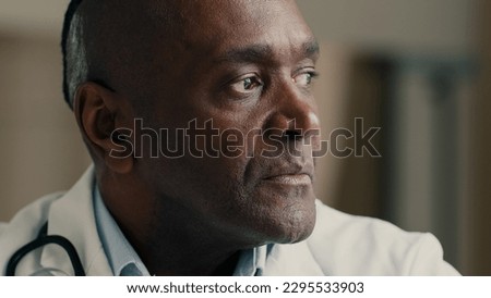 Medical portrait mature doctor general practitioner cardiologist therapist physician looking at camera smiling african ethnic medic scientist in white coat experienced specialist close up front view