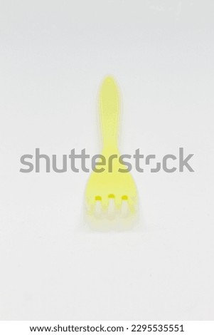 isolated photo of yellow plastic fork on white background
