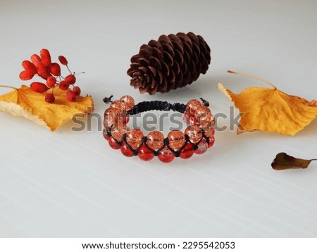 Orange bracelet on a white. Orange bracelet and leafs