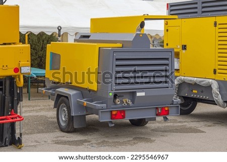 Portable Diesel Air Compressor Mobile Trailer at Construction Site Royalty-Free Stock Photo #2295546967