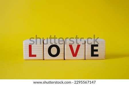 Love symbol. Concept word Love on wooden cubes. Beautiful yellow background. Business and Love concept. Copy space.