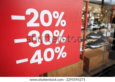 Bright red discount sign with percentages" -20%, -30%, -40%" on shoe store
