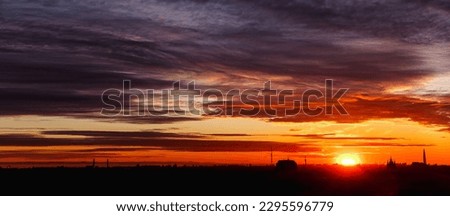 Large aerial panorama of silhouettes cityscape at amazing city orange sunset background. Panoramic view of evening urban landscape for ad poster. Horizon of night city life, skyline. Copy text space