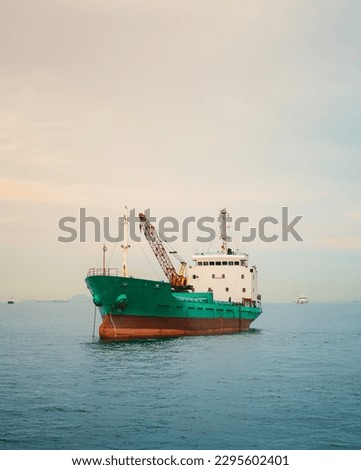Cargo ship in the middle of the sea at the border between Indonesia and Singapore when sunset.