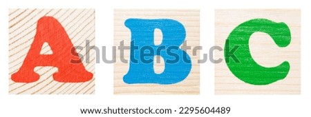 Three letters ABC. Red, blue and green colors. Isolated on wooden background