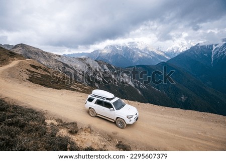 Driving car on high altitude mountain trail, China Royalty-Free Stock Photo #2295607379