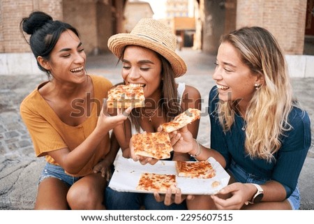 Funny group of three girls and they have fun eating pizza in the touristic city. Italian woman having street food. High quality photo Royalty-Free Stock Photo #2295607515