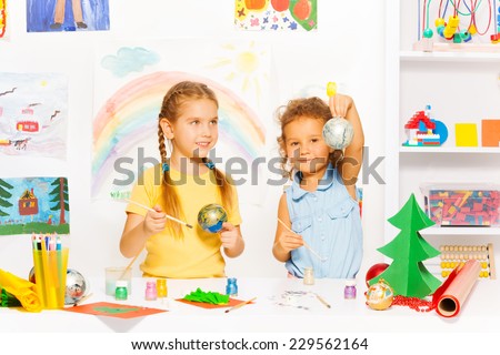 Girls painting New Year balls for Christmas tree
