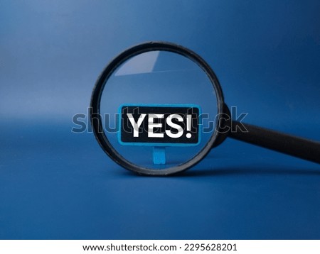 Magnifying glass with the word YES on blue background