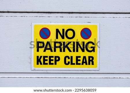 No parking keep clear sign, black text on yellow