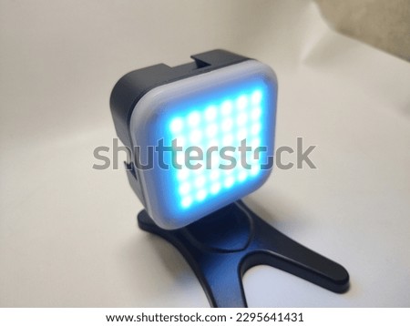 additional led lights to add photo and video lighting, black in metal, with a white lamp cover that can be opened and various color filters inserted, white background