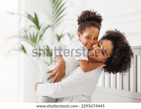 Happy ethnic family. African american mother and daughter play and laugh in bed an home Royalty-Free Stock Photo #2295674445