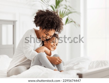 Happy ethnic family. African american mother and daughter play and laugh in bed an home Royalty-Free Stock Photo #2295674447