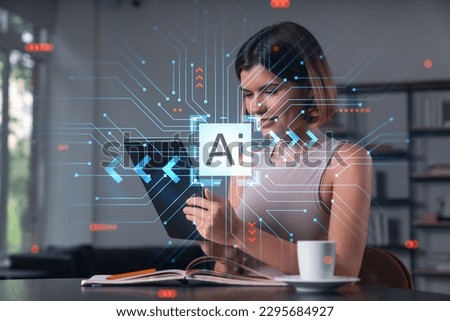 Smiling businesswoman in casual wear holding tablet device touching it at office workplace. Concept of distant work, business education, information technology. Ai hologram Royalty-Free Stock Photo #2295684927