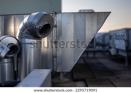 External unit of commercial air conditioning and ventilation system installed on industrial building roof. Exhaust vent on flat factory rooftop Royalty-Free Stock Photo #2295719091