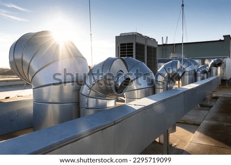 External unit of commercial air conditioning and ventilation system installed on industrial building roof. Exhaust vent on flat factory rooftop Royalty-Free Stock Photo #2295719099