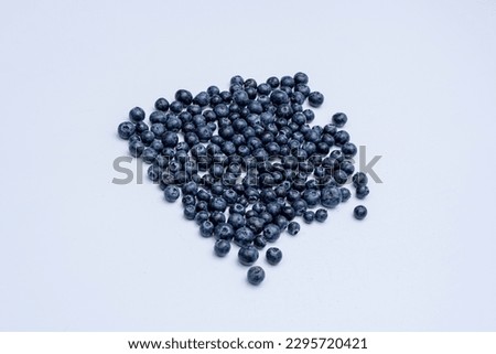 Scattered blueberry fruit on a light background