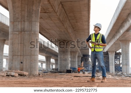 A civil engineer is inspecting a road or expressway construction project under a road under construction. Royalty-Free Stock Photo #2295722775