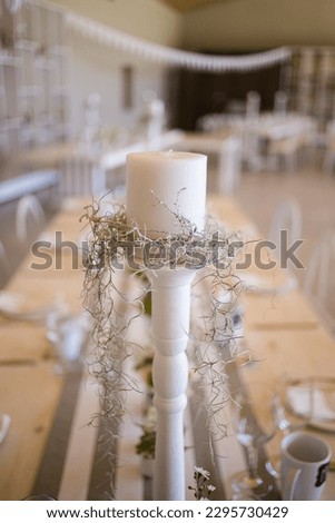This captivating image showcases the elegant decor and stunning floral arrangements of a real wedding. The photograph features a beautifully decorated table in a charming wedding venue.