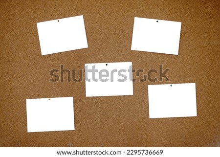 Full frame bulletin board made of cork with a five blank postcards pinned with thumbtacks to it. Each blank postcard can be filled with text or photo.